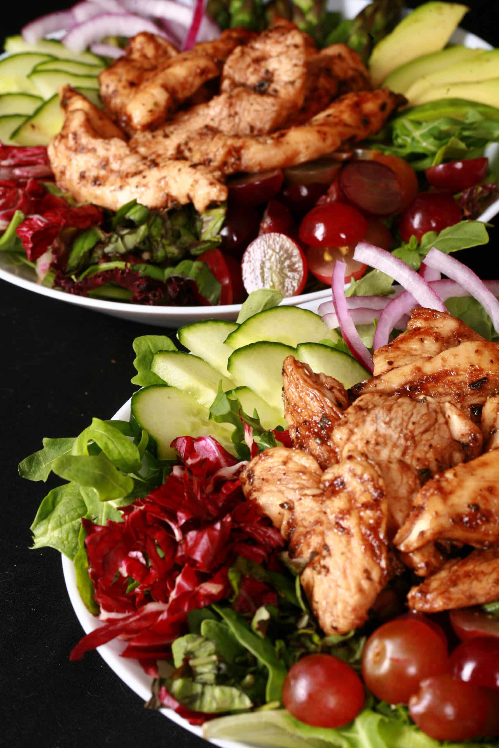 A balsamic chicken with red grapes and a bottle of homemade grape balsamic vinaigrette.