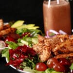 A balsamic chicken with red grapes and a bottle of homemade grape balsamic vinaigrette.