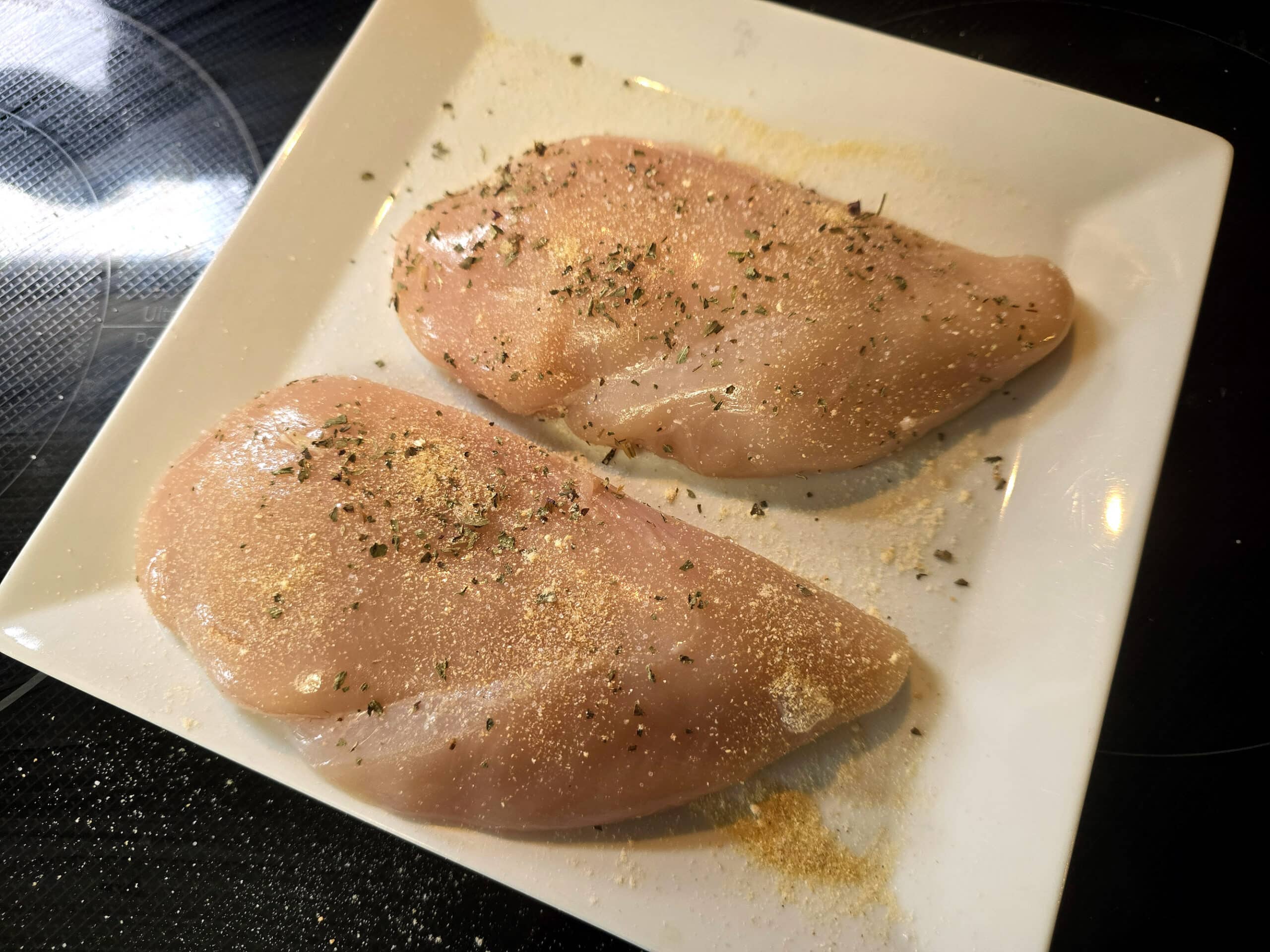 2 seasoned chicken breasts in a pan.