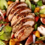 A main dish fall chicken salad with apples, roasted squash, figs, and more. There is a bottle of maple balsamic vinaigrette.