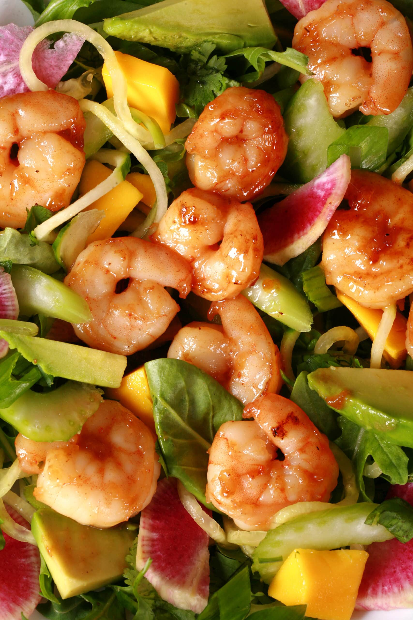 2 bowls of colourful calamansi glazed shrimp salad, with mangoes and a bottle of calamansi vinaigrette.