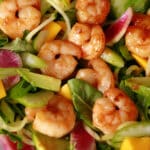 2 bowls of colourful calamansi glazed shrimp salad, with mangoes and a bottle of calamansi vinaigrette.