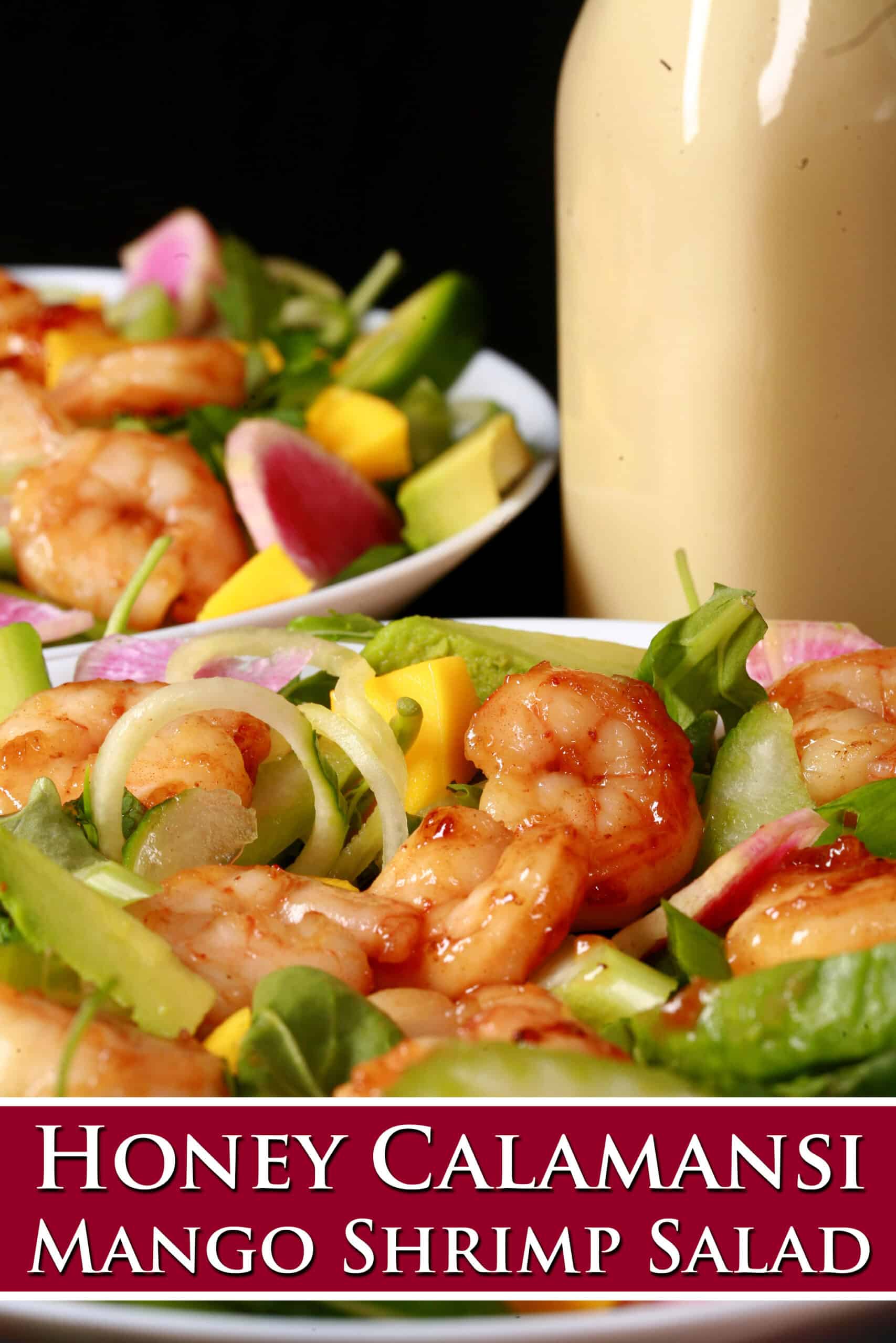 2 bowls of colourful mango shrimp salad, with a bottle of calamansi vinaigrette. Overlaid text says honey calamansi mango shrimp salad.