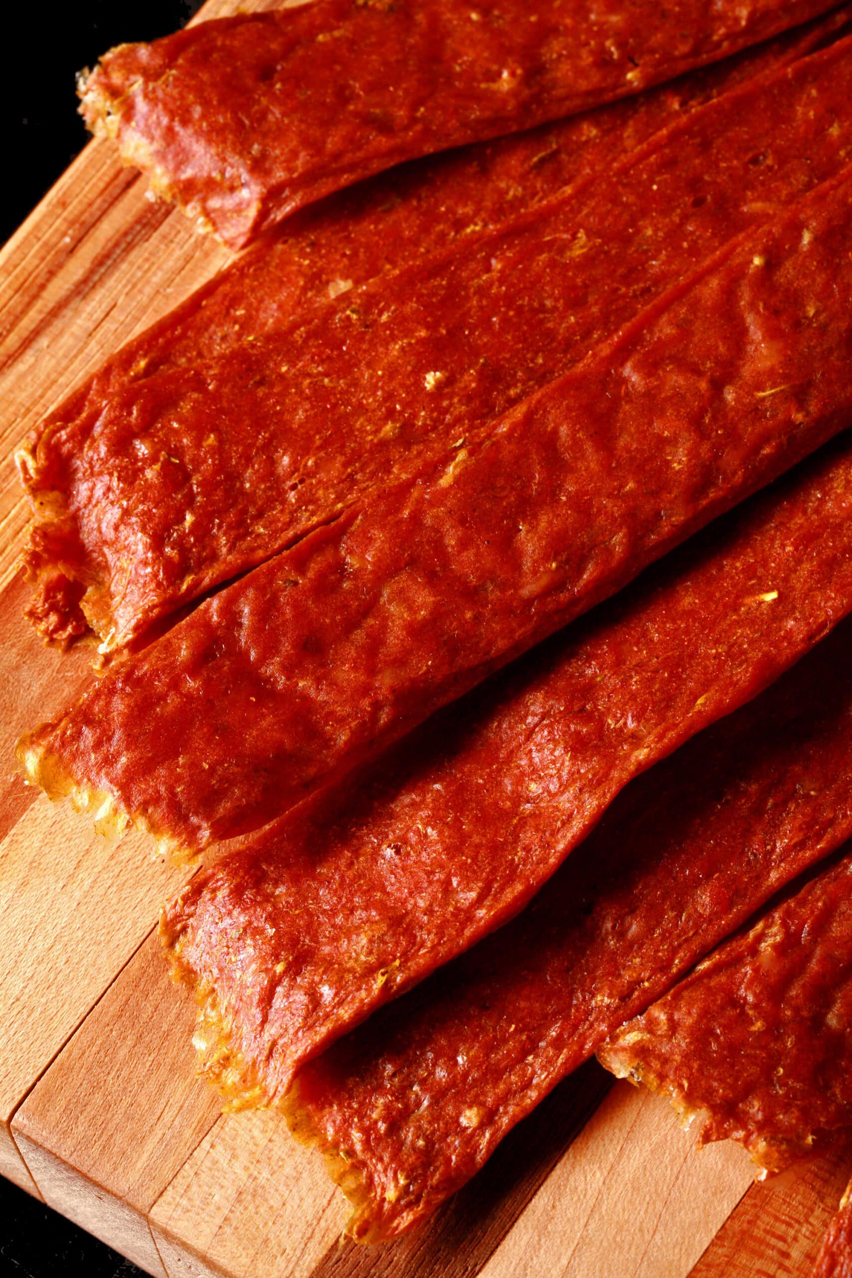 Several strips of shawarma chicken jerky on a cutting board.