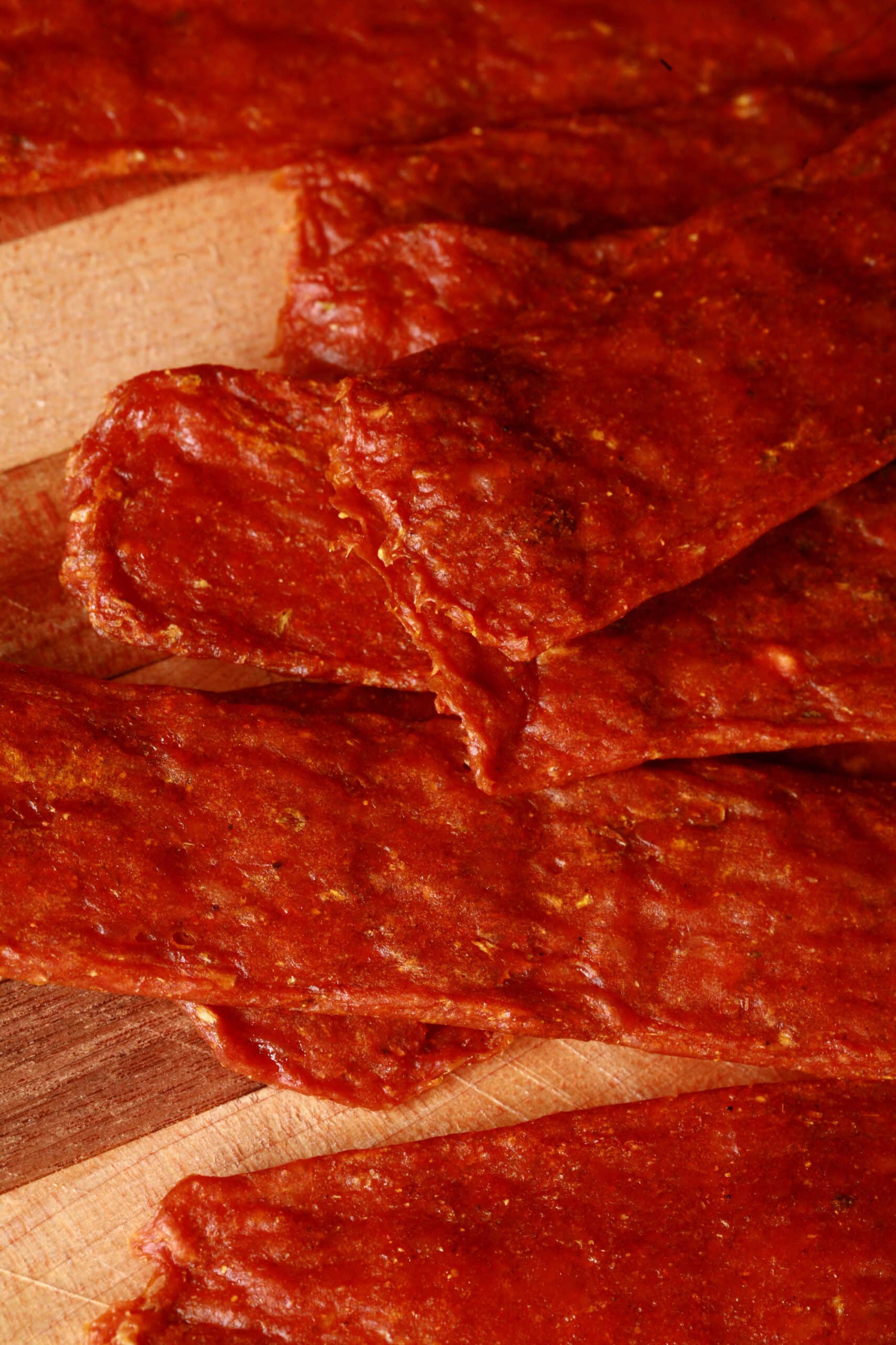 Several strips of shawarma chicken jerky on a cutting board.