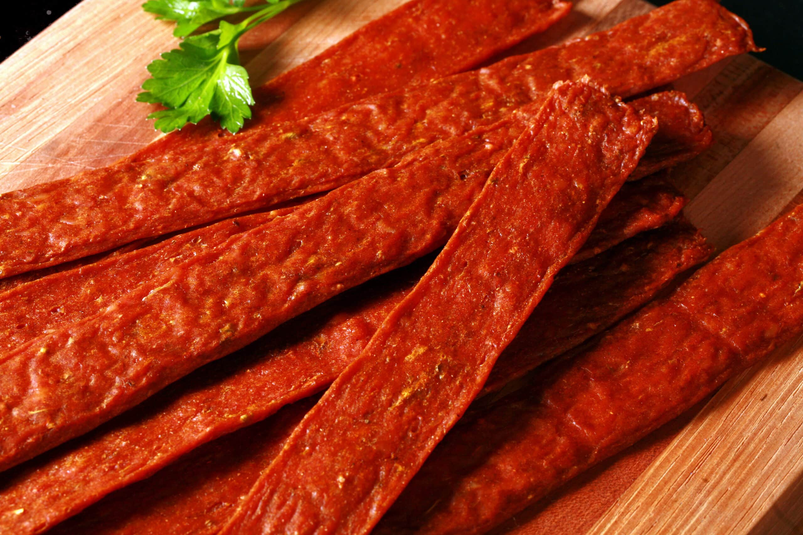 Several strips of shawarma chicken jerky on a cutting board.