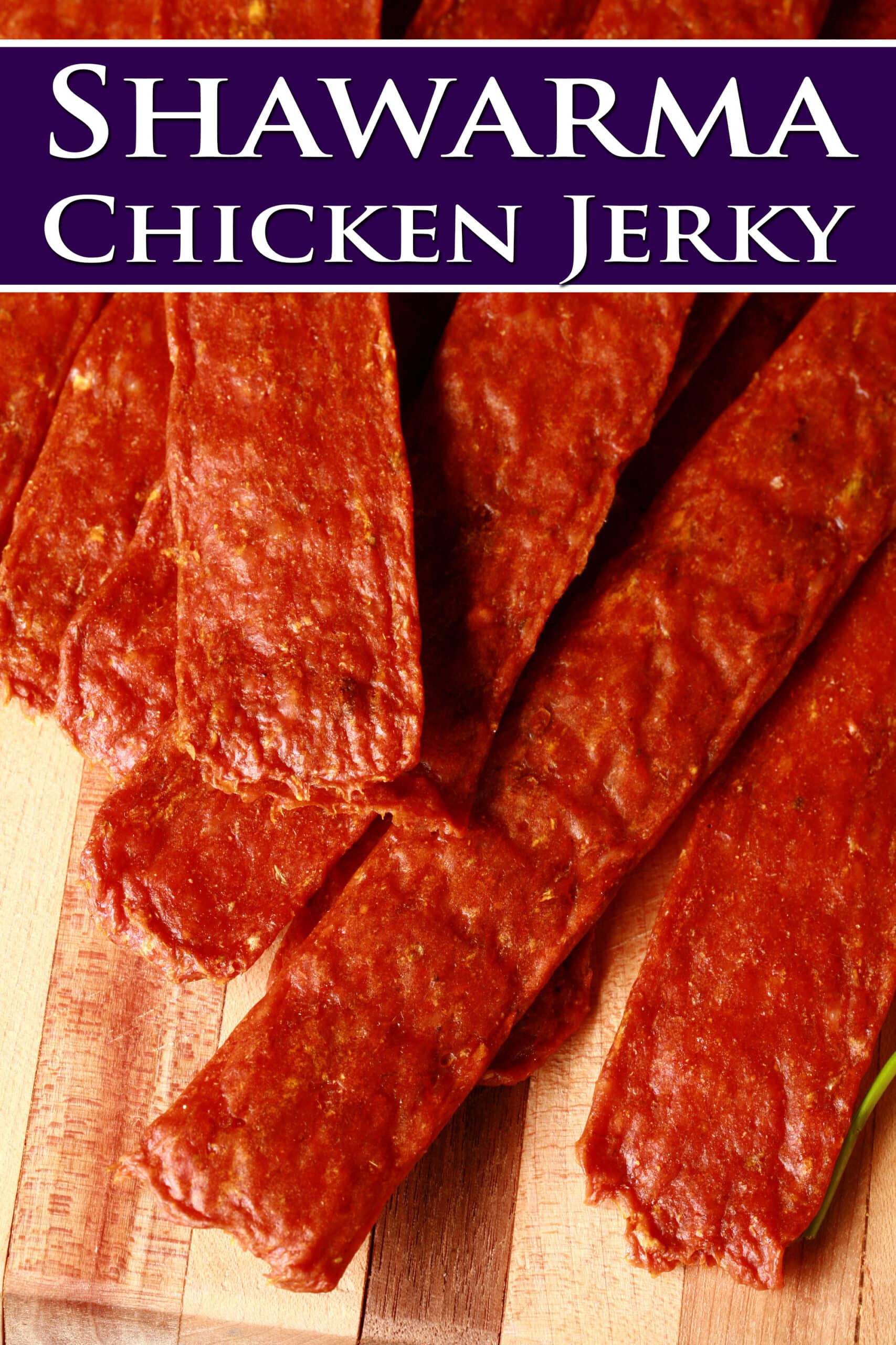 Several strips of shawarma spiced chicken jerky on a cutting board.  Overlaid text says shawarma chicken jerky.