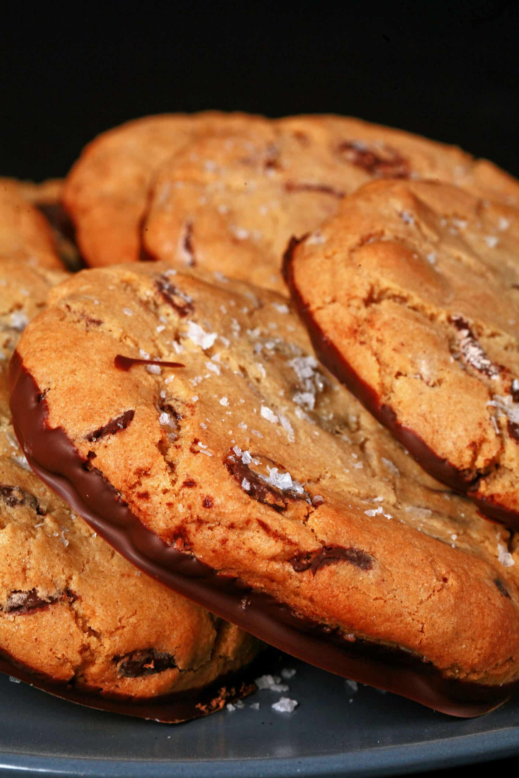 A plate of huge gluten free chocolate chip cookies sprinkled with sea salt.