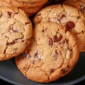 A plate of huge gluten free chocolate chip cookies sprinkled with sea salt.