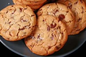 A plate of huge gluten free chocolate chip cookies sprinkled with sea salt.