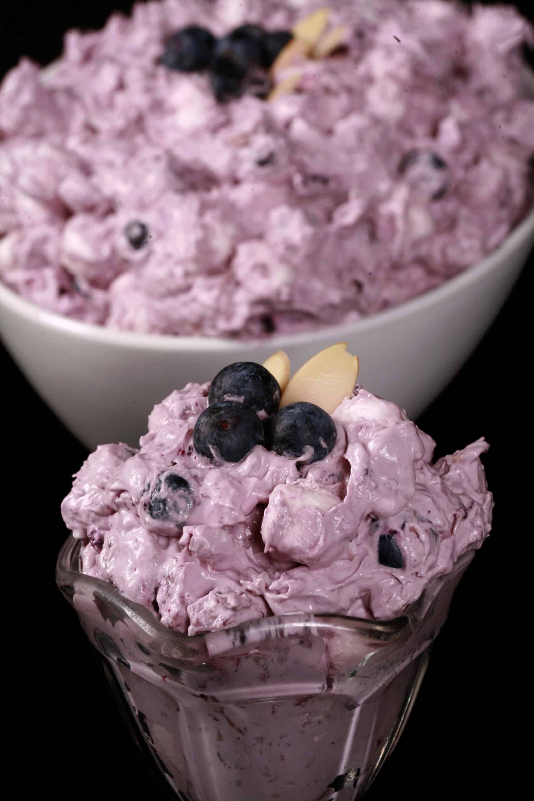 A bowl of blueberry fluff salad with mini marshmallows, almonds, and crushed pineapple.