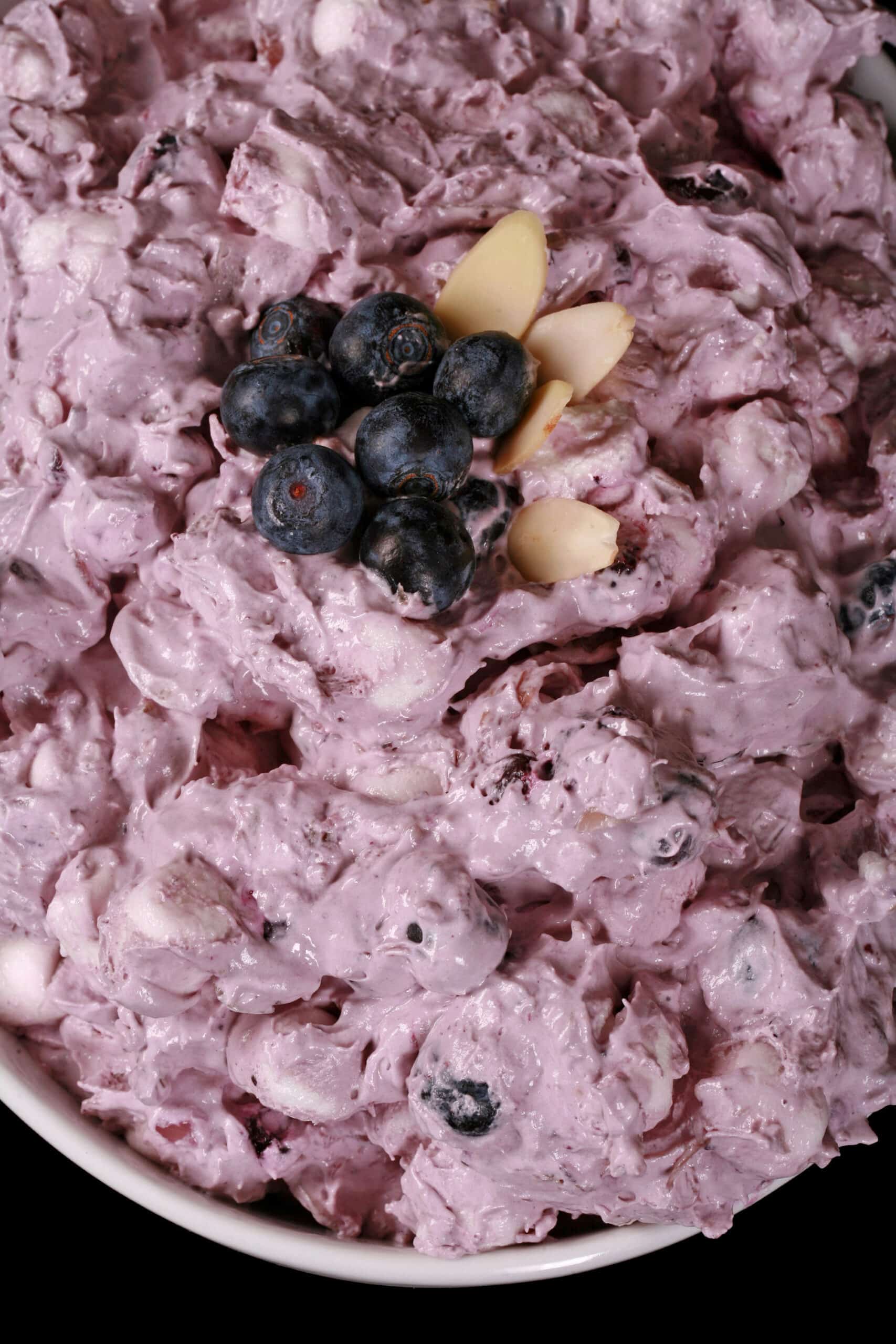 A bowl of blueberry and marshmallow fluff salad.