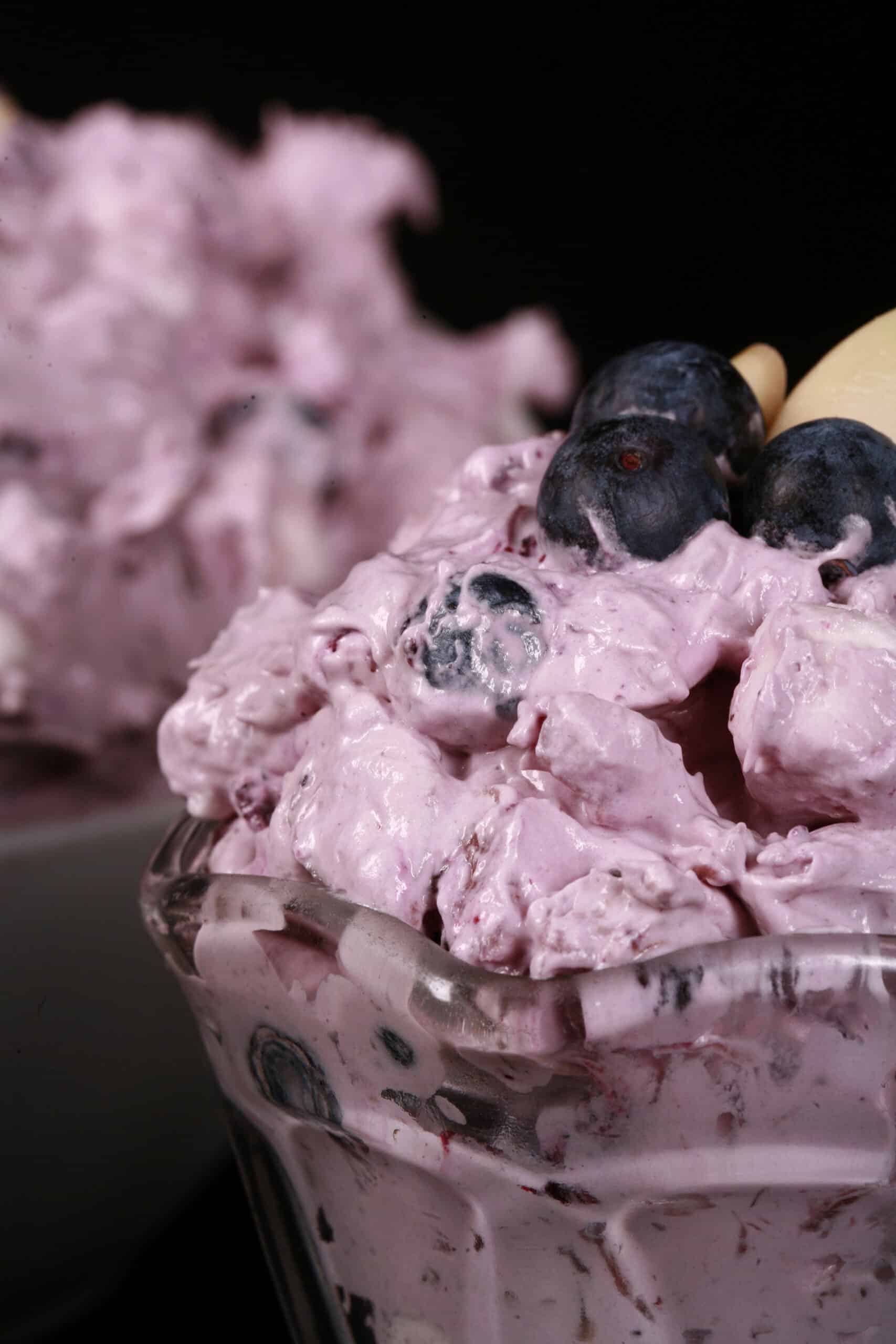 A bowl of blueberry fluff salad with mini marshmallows, almonds, and crushed pineapple.