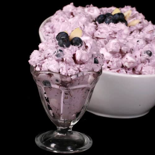 A bowl of blueberry and marshmallow fluff salad.