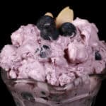 A bowl of blueberry fluff salad with mini marshmallows, almonds, and crushed pineapple.