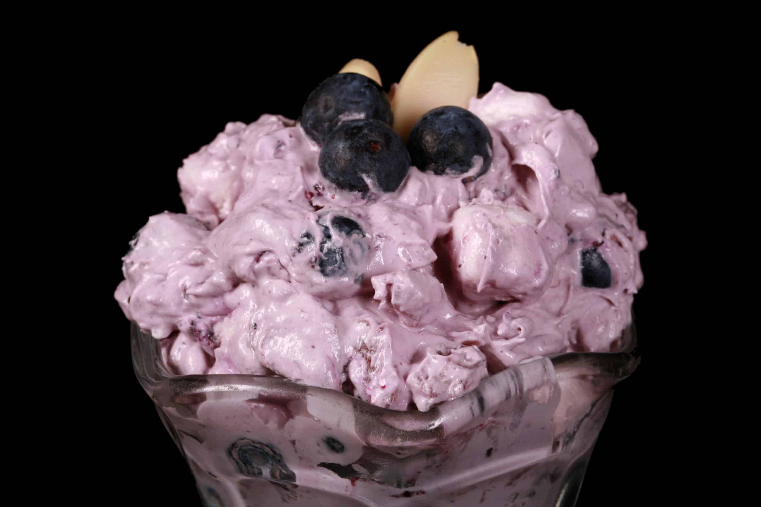 A bowl of blueberry fluff salad with mini marshmallows, almonds, and crushed pineapple.