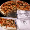 Several freezer bags of homemade gluten-free pizza dough mix, with baked pizza on a plate.