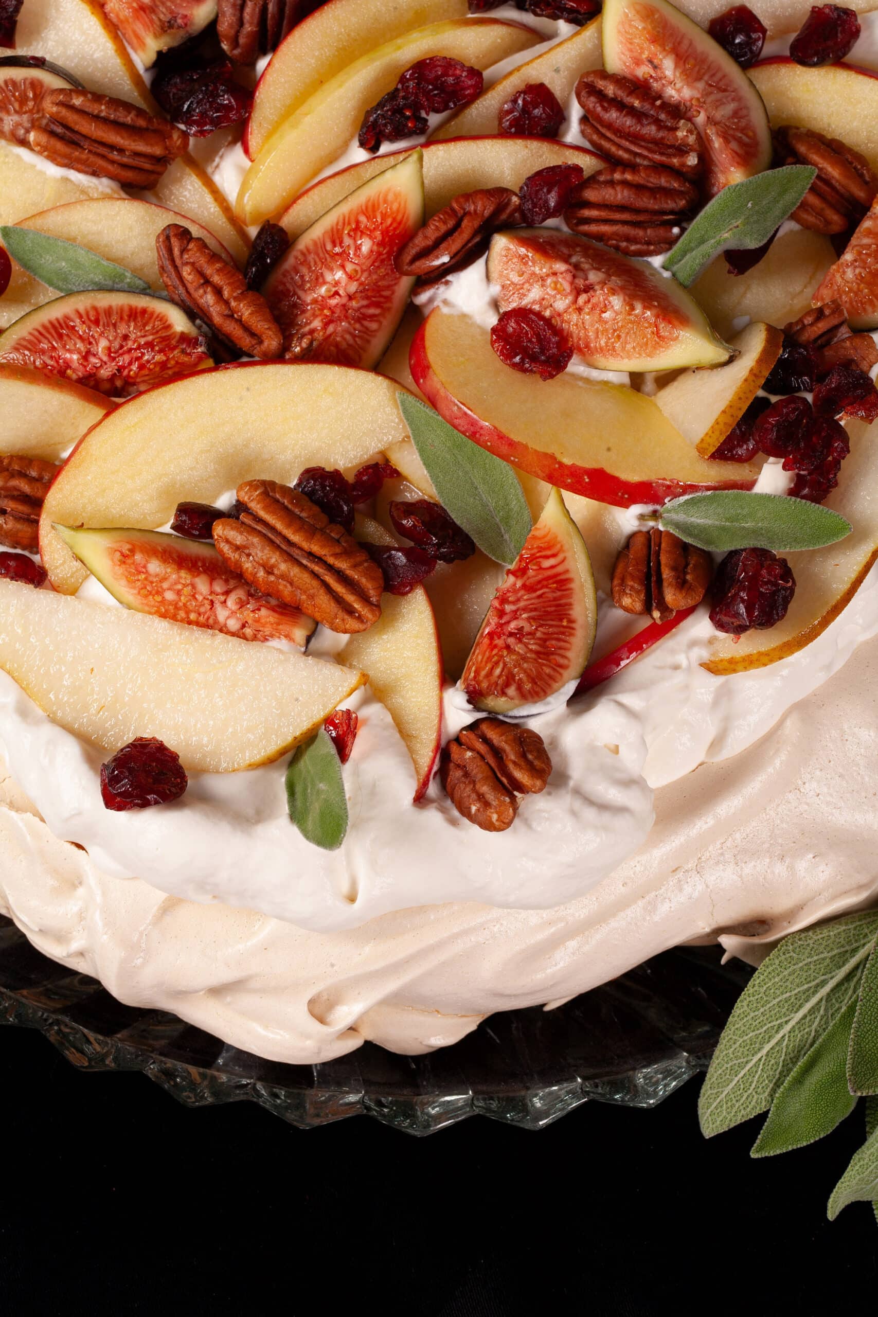 A Thanksgiving pavlova with maple meringue base, maple syrup whipped cream, apples, pears, figs, pecans, dried cranberries, and sage leaves.