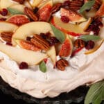 An Autumn pavlova with maple meringue base, maple syrup whipped cream, apples, pears, figs, pecans, dried cranberries, and sage leaves.