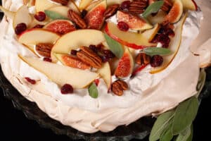 An Autumn pavlova with maple meringue base, maple syrup whipped cream, apples, pears, figs, pecans, dried cranberries, and sage leaves.