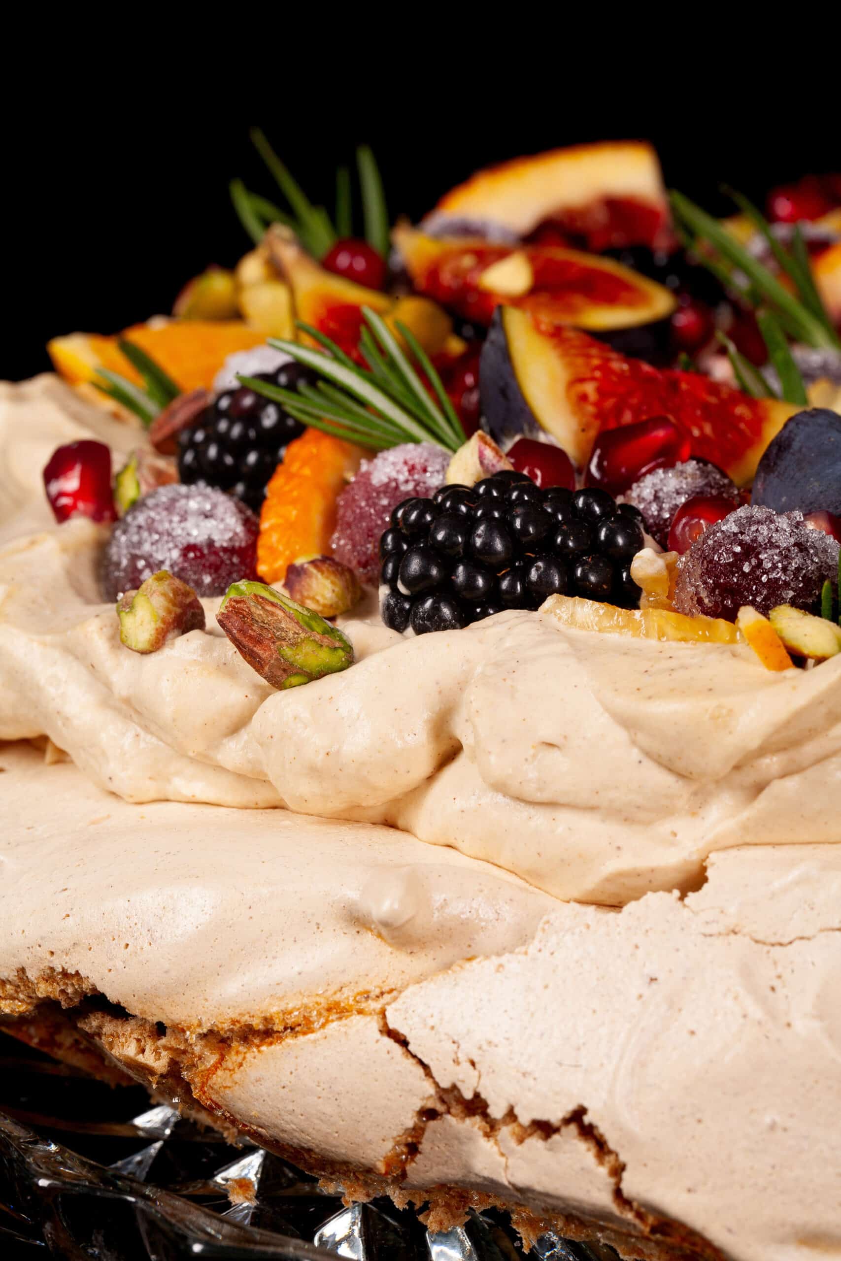 A gingerbread pavlova with a gingerbread meringue base, gingerbread flavoured whipped cream, figs, oranges, sugared cranberries, blackberries, pomegranate arils, pistachios, and rosemary.