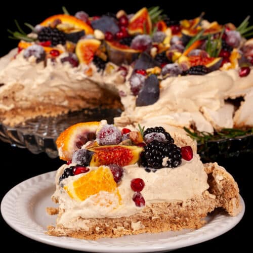A gingerbread pavlova with a gingerbread meringue base, gingerbread flavoured whipped cream, figs, oranges, sugared cranberries, blackberries, pomegranate arils, pistachios, and rosemary.