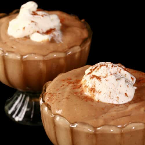 2 bowls of gingerbread pudding, with whipped cream and cinnamon on top.